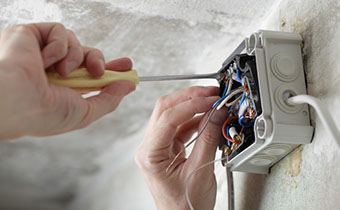 image of a person fixing some sockets and wiring